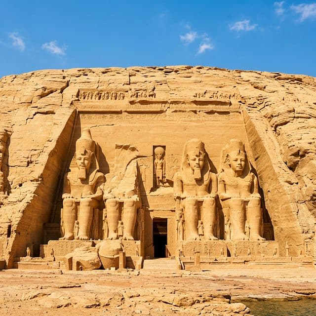 Four colossal statues of Ramesses II carved into the golden sandstone facade of Abu Simbel temple